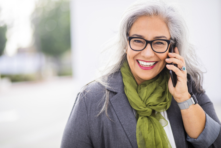 A smiling patient contacting Masci, Hale & Wilson Advanced Aesthetic and Restorative Dentistry, at Montgomery, NY on a cell phone.