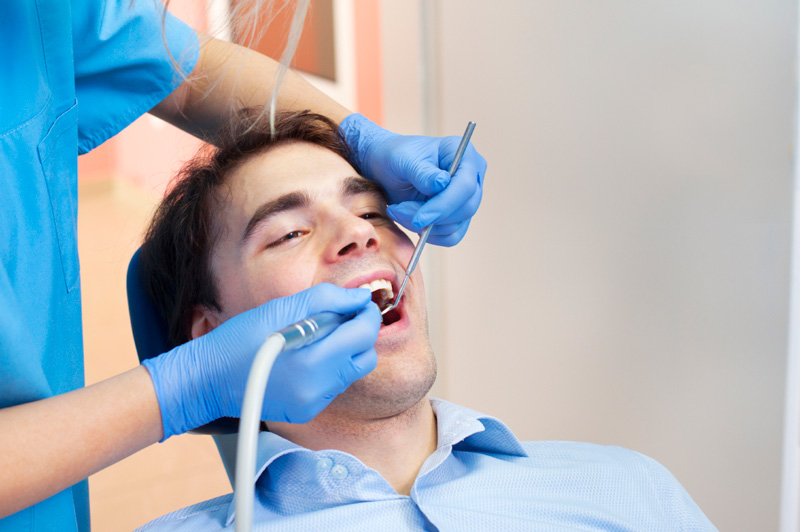 Man receiving dental cleaning from dental hygienist at Masci & Hale Advanced Aesthetic and Restorative Dentistry in Montgomery, NY